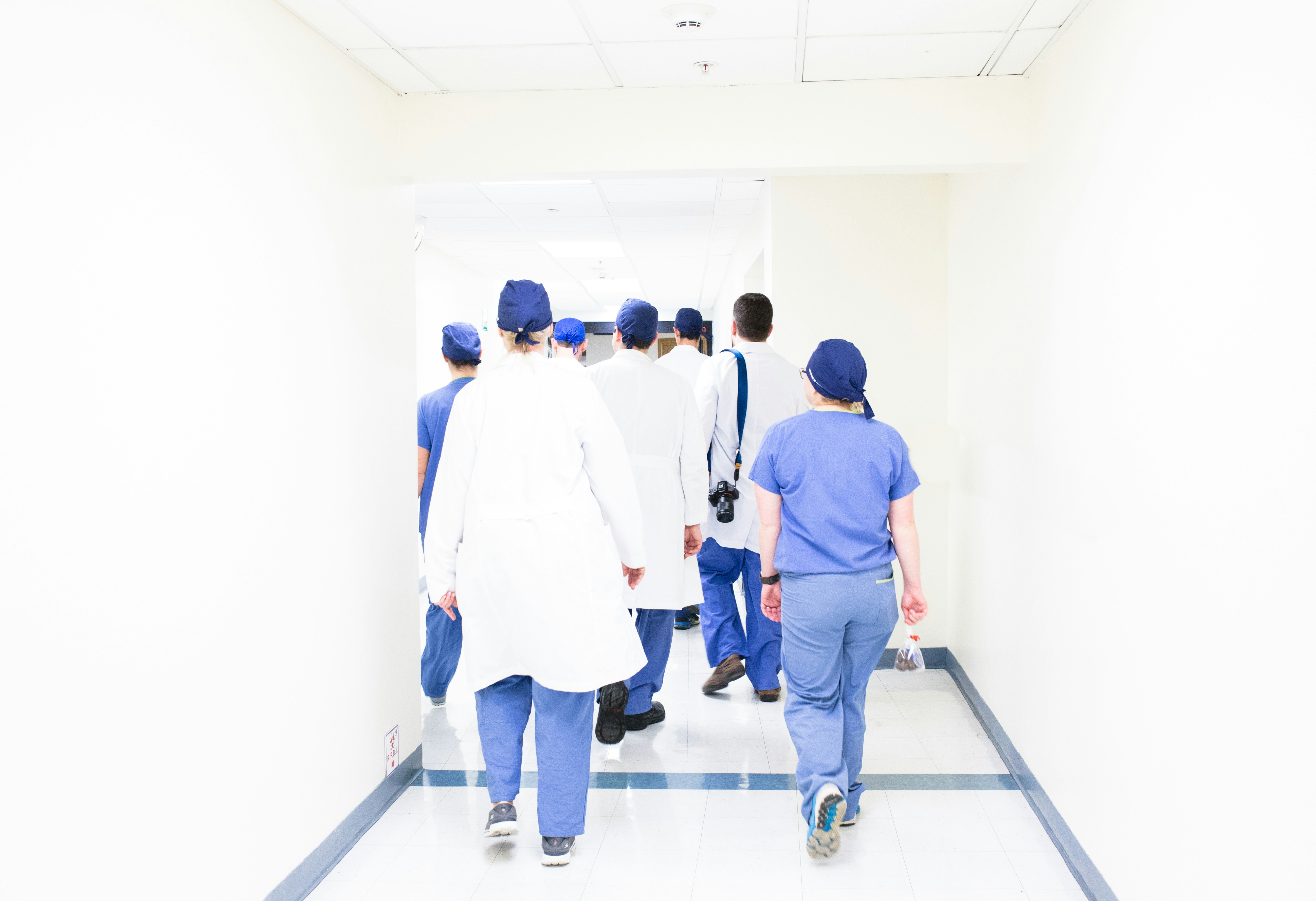 Image of a group of doctors walking away from the camera.